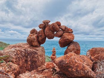 Rocks on sea shore against sky