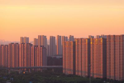 Modern buildings against sky during sunset