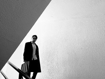 Young man standing against wall