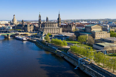 River amidst buildings in city against clear sky