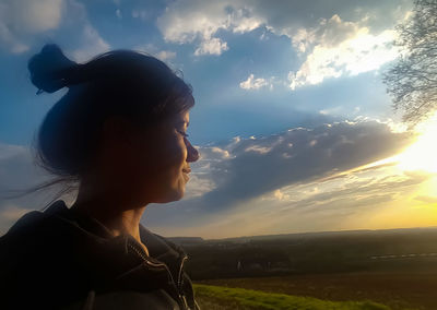 Young woman on field against sky