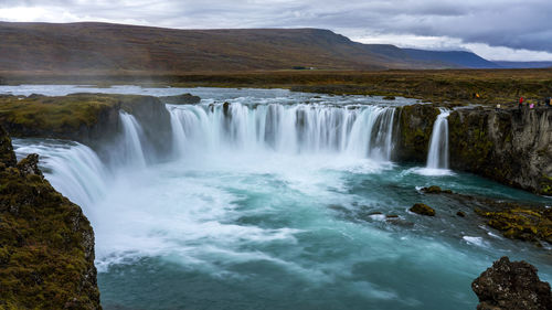 Scenic view of waterfall against sky