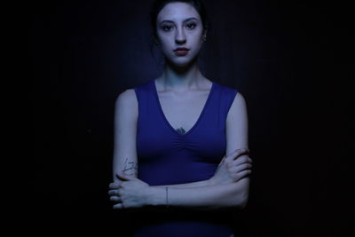 Close-up of young woman against black background