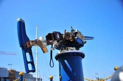 Low angle view of cranes against blue sky