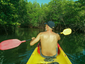 Rear view of shirtless man in lake