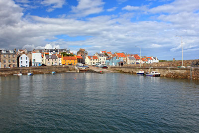 View of river by town against sky