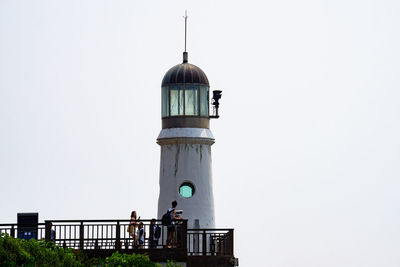 Low angle view of lighthouse against building