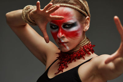 Portrait of young woman with eyes closed against wall