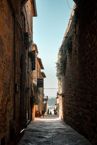 Narrow alley amidst buildings against clear sky