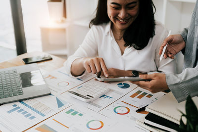 Midsection of business colleagues working on table