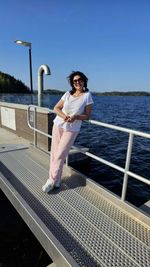 Full length of young woman standing on railing