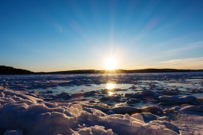 Scenic view of frozen sea against sky during sunset