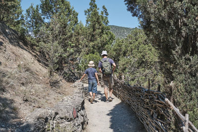 A boy and a man hiking on the scenic golitsyn trail. national botanical reserve new world, crimea. 