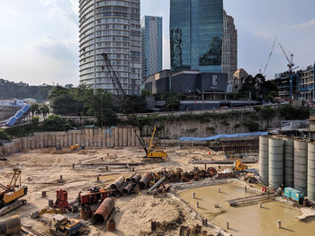 Construction site by buildings against sky in city