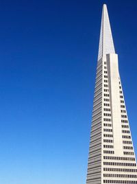 Low angle view of modern buildings against clear blue sky