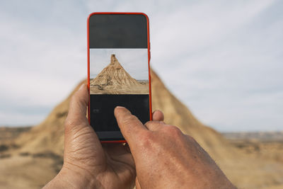 Taking photos with a smartphone of a castil de tierra peak, close-up shot