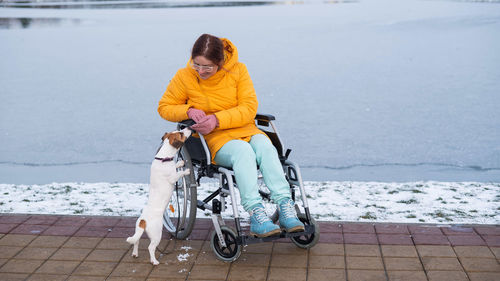 Side view of woman riding bicycle on snow