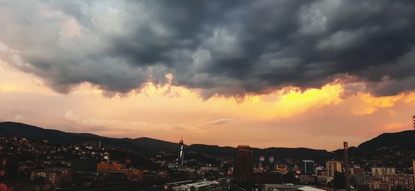 City against dramatic sky during sunset