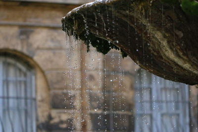 Close-up of water flowing at fountain against building