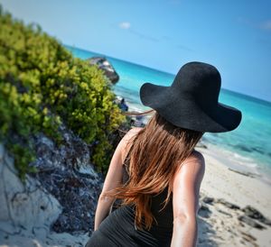 Rear view of woman wearing hat against sea