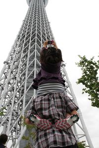 Low angle view of woman standing on railing