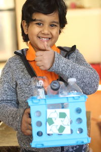 Close-up portrait of smiling boy holding camera