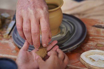 Cropped hands of person making pot