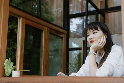 Portrait of young woman looking away at window