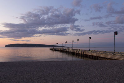 Pier over sea against sky during sunset