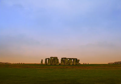 Old ruin on field against sky during sunset