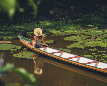 Rear view of man kayaking in lake