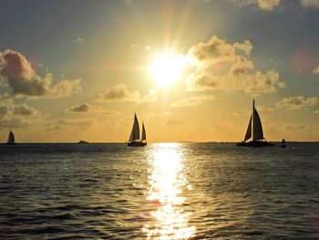 Sailboat sailing on sea against sky during sunset