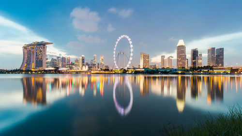 Scenic view of illuminated city during sunset