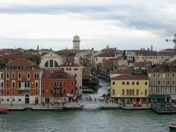 View of buildings in city against cloudy sky