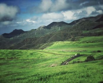 Scenic view of field and mountains against sky