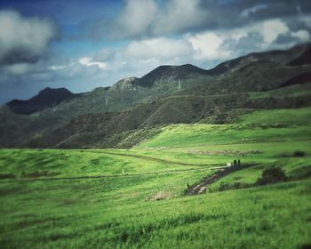 Scenic view of field and mountains against sky