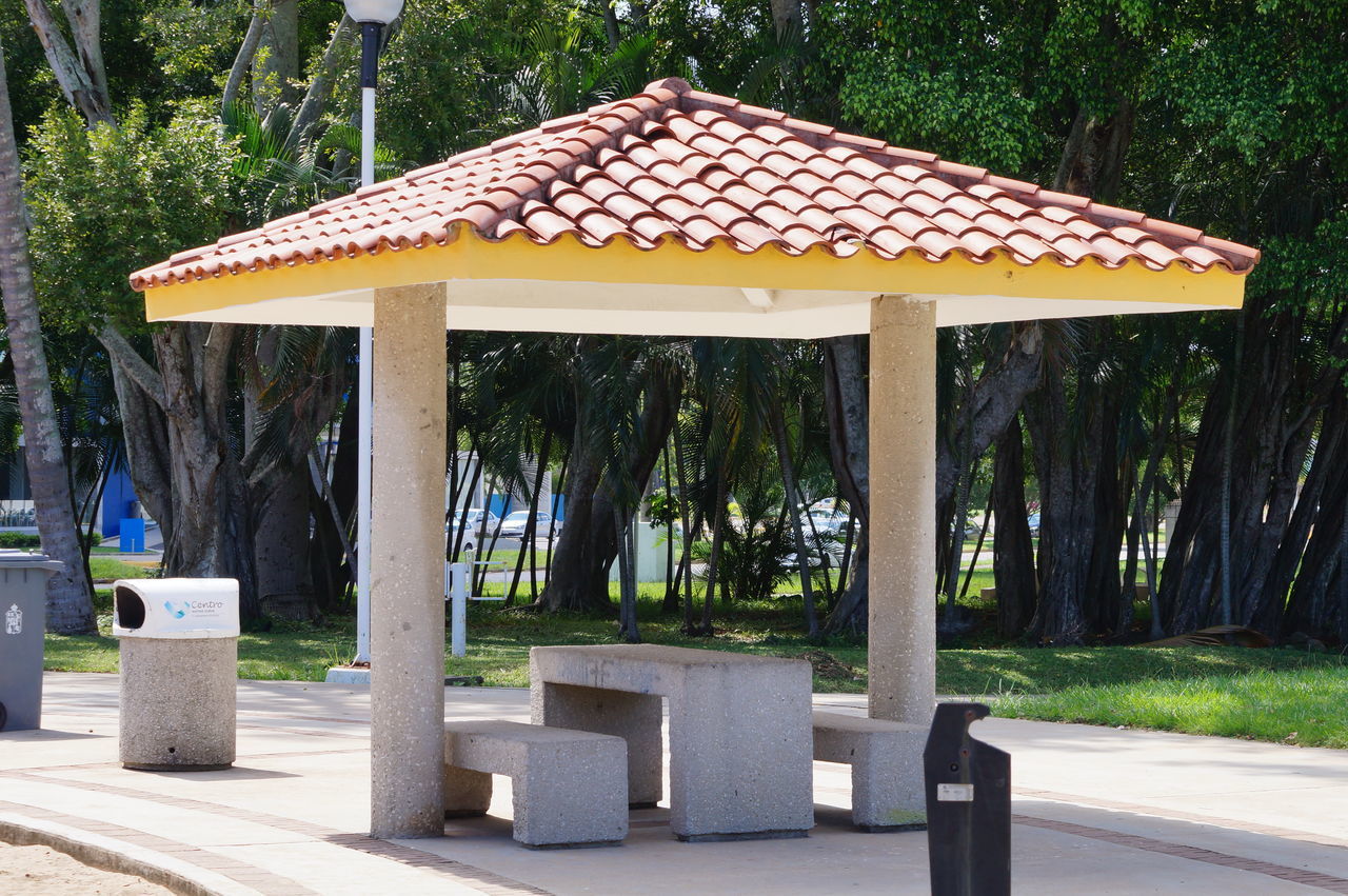 GAZEBO IN PARK BY TREES AND BUILDING