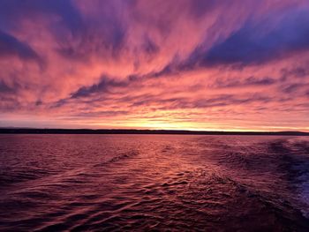 Scenic view of sea against dramatic sky during sunset