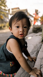 Portrait of cute girl sitting outdoors