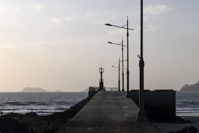 Pier over sea against sky during sunset