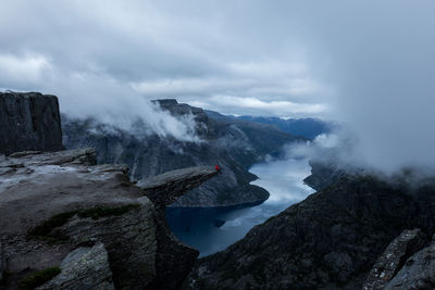 Scenic view of mountains and river against sky during foggy weather