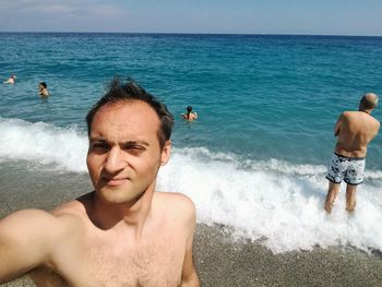 Portrait of shirtless man standing at beach