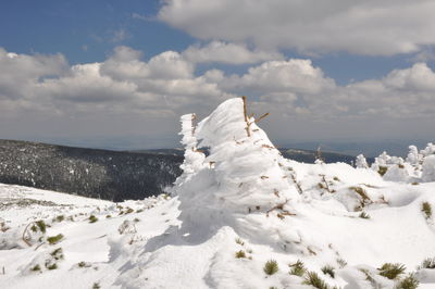 Snow covered land against sky
