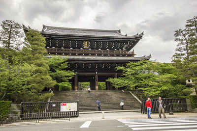 People outside temple against building