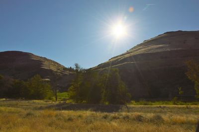 Scenic view of mountains against clear sky on sunny day