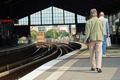 Rear view of people standing on railroad station platform
