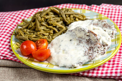 Close-up of food served in plate on red tablecloth