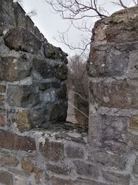 Low angle view of stone wall against sky