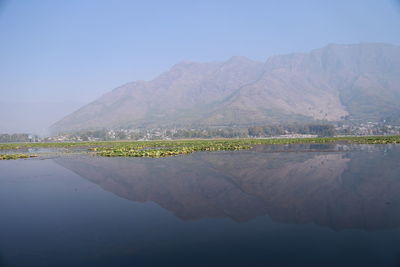 Scenic view of lake by mountains against sky