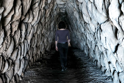 Rear view of woman standing in tunnel